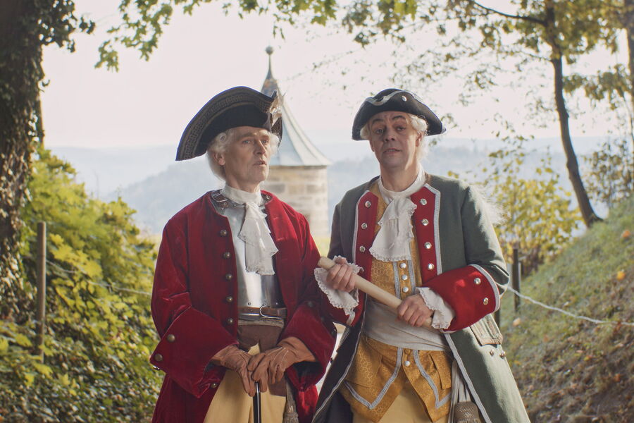 Standbild aus der Filmprojektion: Festungskommandant und Architekt in historischen Uniformen des 18. Jahrhundertsim Gespräch