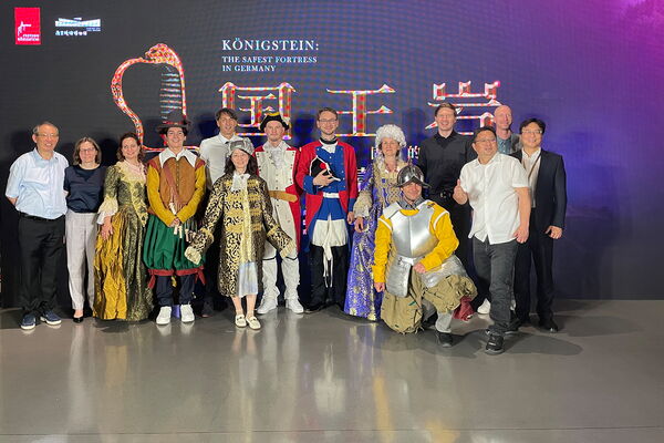 Mitarbeiter der Festung Königstein und desStadtmauermuseums von Nanjing - teils in Kostümen, die die Museumsbesucher für Selfies anziehen dürfen