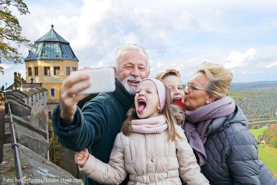 Oma und Opa machen Selfies mit Enkelkindern vor der Friedrichsburg
