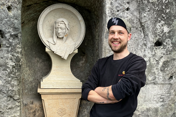 Steinbildhauer Thore Brilloff neben dem Medaillon der Königin Maria Anna von Sachsen in der Mariengrotte