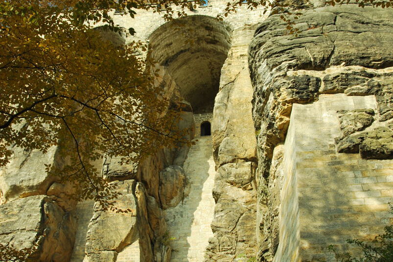 Blick vom Patrouillenweg auf gemauerte Rundbögen zwischen natürlichen Felsen