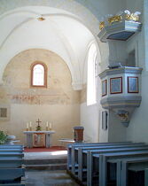 Altarraum der Kirche mit Kanzel an der rechten Seite und den Kirchenbänken
